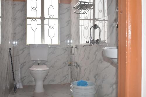 un baño con inodoro y lavabo en Elysian Home Food & Stay, en Shillong