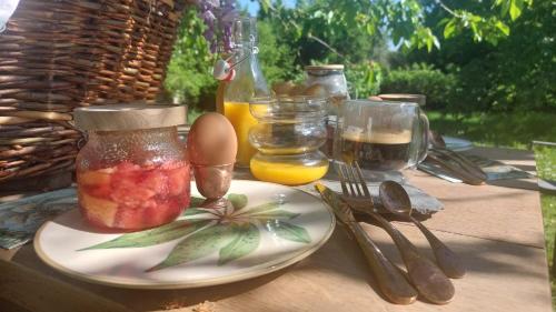 a table with a plate with a jar of fruit on it at A la LampePigeon, un gîte avec jardin et du calme, 3 min de la Ferté-sous-Jouarre, 42 min de Paris TER, 35 min de Disney, 10 min de l'A4 in Reuil-en-Brie