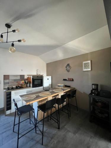 une cuisine avec une table et des chaises dans une pièce dans l'établissement Reflets de montagnes, à Chambéry