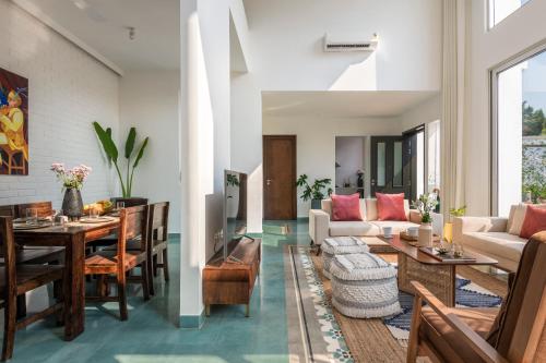 a living room with a table and a couch at La Olalian 2 & 3 BHK Designer Villas Near Anjuna Beach with Private Pool & Sun Deck & Garden in Anjuna