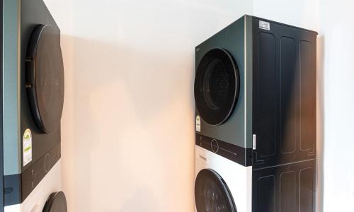 a wall with two washer and dryer at Anyang CNC Hotel in Anyang