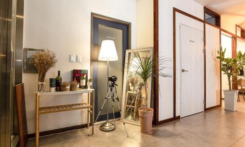 a room with a lamp and a plant and a door at Anyang CNC Hotel in Anyang
