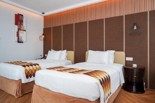 a hotel room with two beds in a room at Cambridge Hotel Medan in Medan