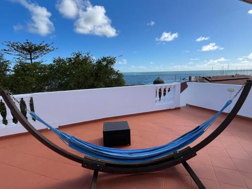 a hammock on a roof with a view of the ocean at AS CEGONHAS - ALOJAMENTo LOCAL in Olhão