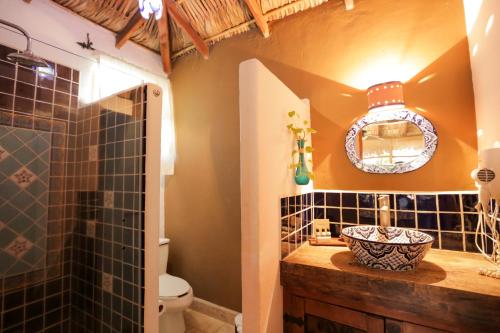 La salle de bains est pourvue d'un lavabo, de toilettes et d'un miroir. dans l'établissement The Bungalows Hotel, à Cabo San Lucas