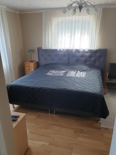 a bedroom with a blue bed and a window at Kuressaare Centrum in Kuressaare