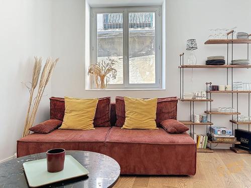 - un salon avec un canapé rouge et des oreillers jaunes dans l'établissement Magnifique Appartement - Centre du Panier - Design - Les Frères de la Loc', à Marseille