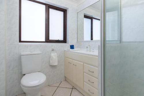Un baño blanco con inodoro y lavabo. en Oxley 5, en Tuncurry