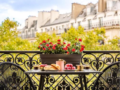 - une table avec de la nourriture et des fleurs sur le balcon dans l'établissement Merveil - Luxury Suite - Louvre -Sebastopol I, à Paris