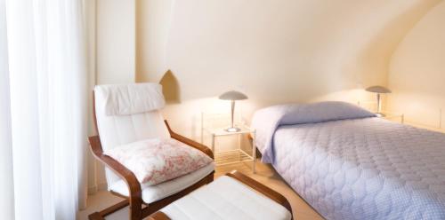 a small bedroom with a bed and a chair at Corte Elvira in Manerba del Garda