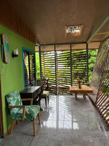 a living room with green walls and a table and chairs at Orgánico Punta Riel in Cahuita