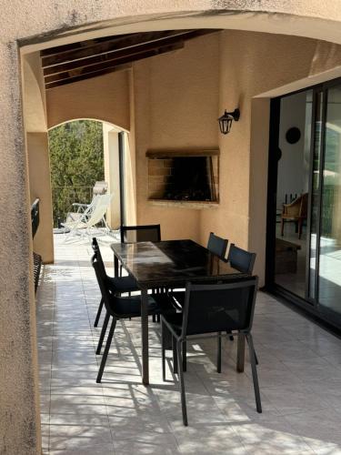 a dining area with a table and chairs on a patio at Altagna in Olmeto