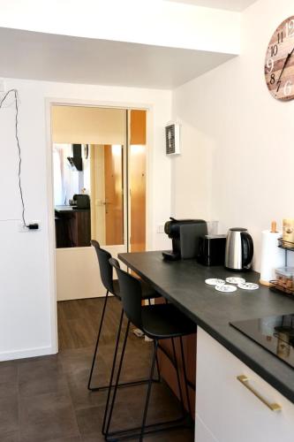 une cuisine avec un comptoir noir et des chaises dans l'établissement Peaceful Home, à Alfortville