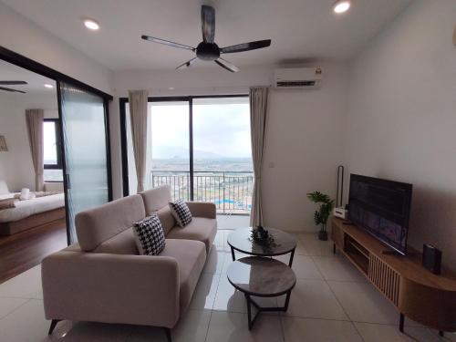 a living room with a couch and a ceiling fan at Sunway Onsen Signature Themepark Suites with Hotspring by IWH Suites in Ipoh