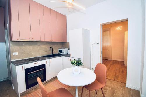 a kitchen with a table and a white table and chairs at Green House Studios in Braşov