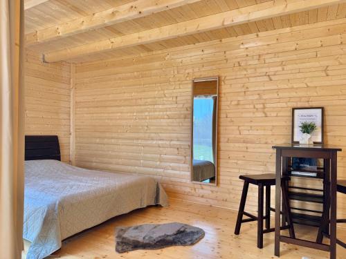 a bedroom with a wooden wall with a bed and a window at Pühajõe Holiday Park in Pühajõe