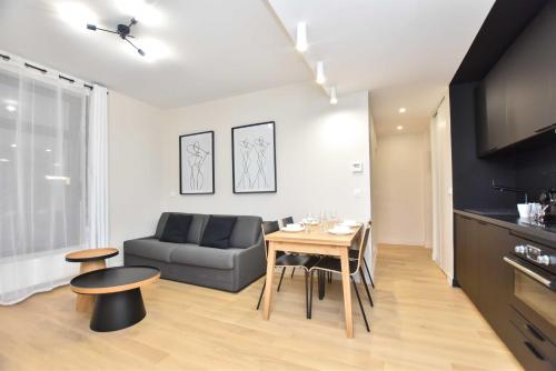 un salon avec une table et un canapé dans l'établissement Peaceful apartment - 2BR-6P - Trocadero, à Paris