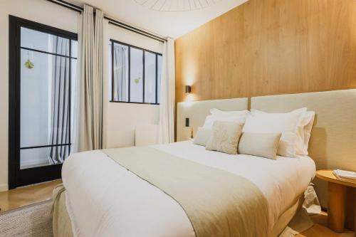 une chambre avec un grand lit blanc et une fenêtre dans l'établissement Welcoming Apartment - 2BR-6P - Bastille, à Paris