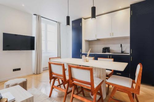 une cuisine avec une table et des chaises dans une pièce dans l'établissement Welcoming Apartment - 2BR-6P - Bastille, à Paris