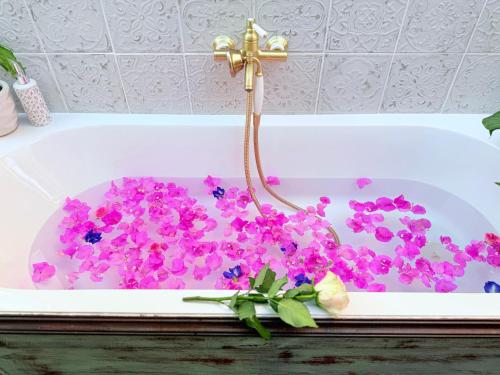 a bath tub filled with purple flowers and a cross at Curieux Refuge in Saint-Paul