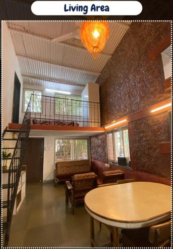 a living room with a table and a living area at Leela villa - Ancient Redstone Escape in Panchgani