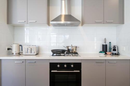 a kitchen with white cabinets and a stove top oven at Modern Clyde House Smart TV*Dryer in Clyde
