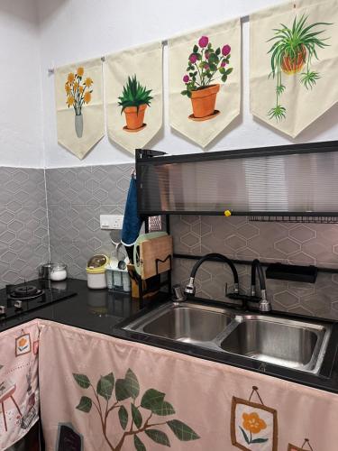 a kitchen with a sink and potted plants on the wall at Myra Guesthouse Bohemian Style Mutiara Ville Duplex Apartment in Cyberjaya