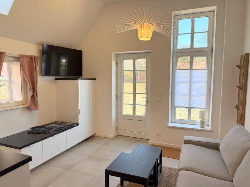a living room with a couch and a table at Timmenhus - neue Ferienwohnungen im historischen Bauernhaus in Timmendorfer Strand