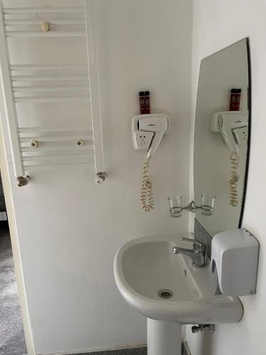 a bathroom with a sink and a mirror and a phone at HOTEL Vitan273 in Bucharest
