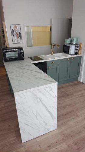 a kitchen with a marble counter top in a room at HYPER CENTRE AVEC JARDIN 47m2 COSY in Boulogne-sur-Mer