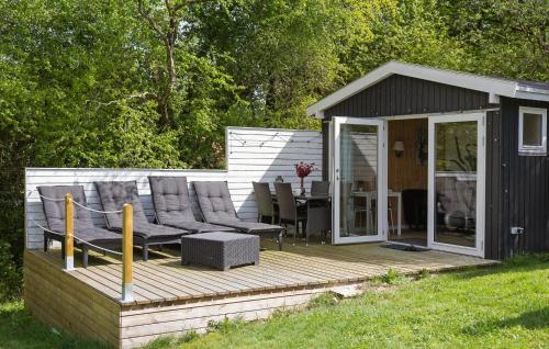 a wooden deck with a table and chairs on it at Holiday Home Ajstrup Strandvej Malling Xi in Malling