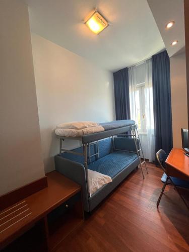 a room with two bunk beds and a table at Hotel La Terrazza in Porto San Giorgio