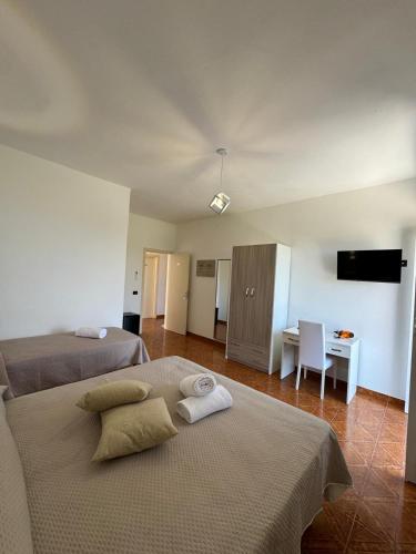 a bedroom with two beds and a table and a television at Villa Chiena Forio in Ischia