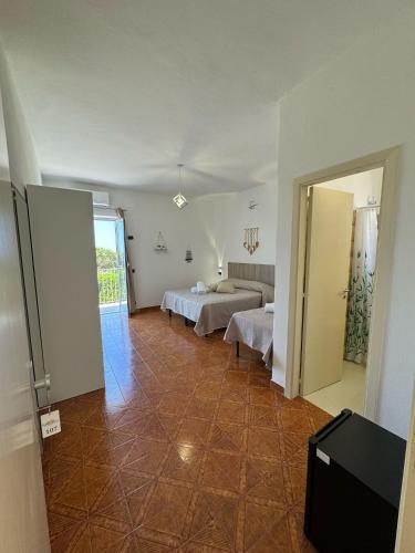 a hotel room with two beds and a hallway at Villa Chiena Forio in Ischia
