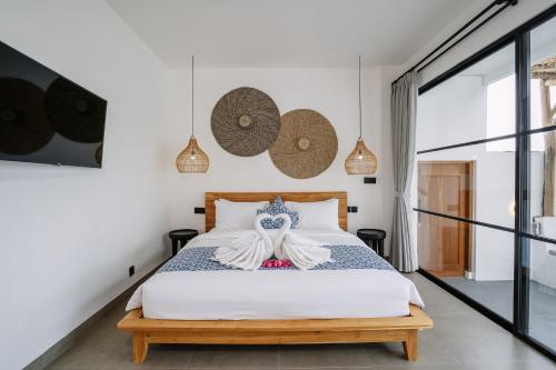 a bedroom with a bed in a room with white walls at Villa Alveena in Tumbak Bayuh in Tumbak Bayuh