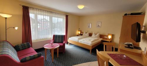 a hotel room with a bed and a living room at Appartementhaus Simon in Bad Füssing