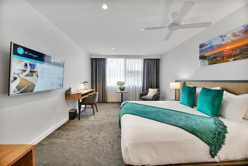 a hotel room with a large bed and a desk at The Remington Orange in Orange