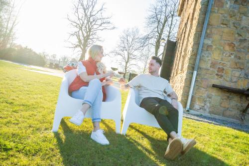 a man and a woman sitting on a chair in the grass at Altes Wasserwerk Tecklenburg in Tecklenburg