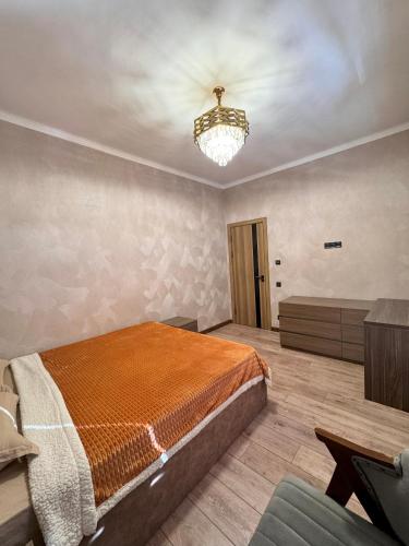 a bedroom with a bed and a chandelier at Mountain paradise Премиум дача в Чимгане in Chimgan