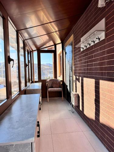 a room with a table and a chair and windows at Mountain paradise Премиум дача в Чимгане in Chimgan