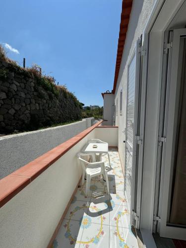 a balcony with chairs and tables on a building at Villa Chiena Forio in Ischia