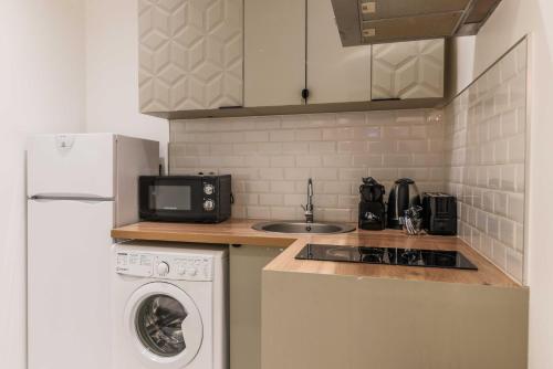 Il comprend une cuisine équipée d'une cuisinière. four supérieur à côté d'un évier dans l'établissement Cosy flat - 1BR-4P - Near Nation, à Paris