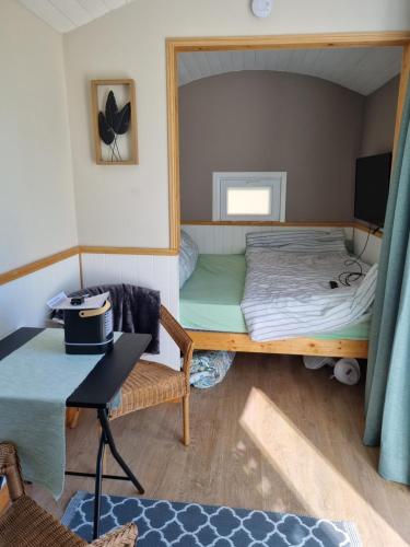 Cette petite chambre comprend des lits superposés et une table. dans l'établissement la petite maison verte, à Plévin