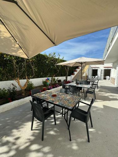 a patio with tables and chairs and umbrellas at Villa Chiena Forio in Ischia