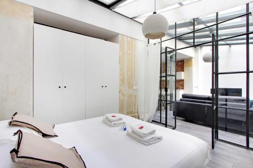 - une chambre avec un lit blanc et un canapé noir dans l'établissement Splendid apartment - 2BR 4P - Sacré-Cœur, à Paris