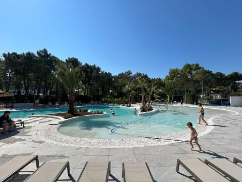 a group of people playing in a swimming pool at Dune Prestige & Chalets in Bibione