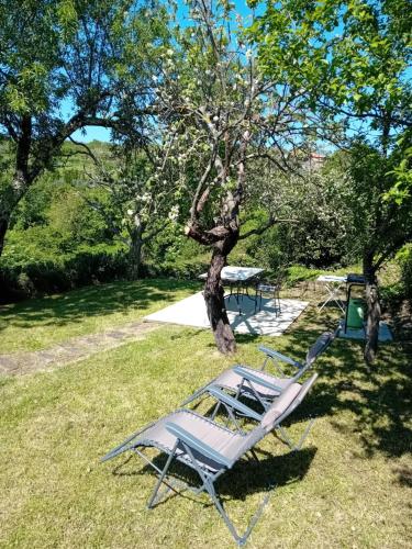 a couple of lawn chairs sitting in the grass at Fig&Lavender Apartment in Šmarje