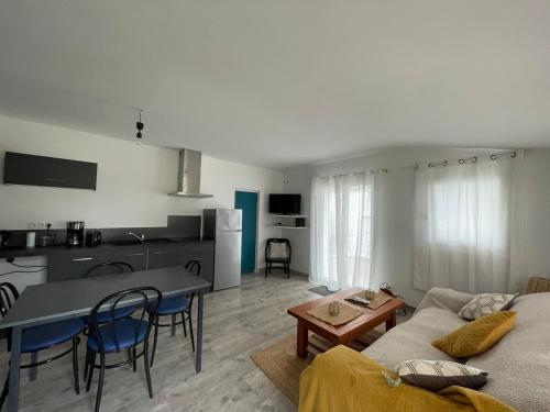 un salon avec un canapé et une table dans l'établissement Chez moon Joli appartement rénové proche centre et parking privé, à La Tremblade