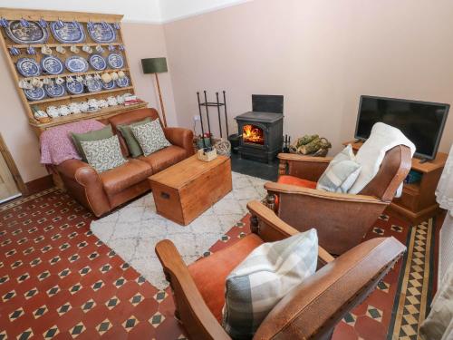 a living room with leather furniture and a fireplace at Llanwern Farm in Fishguard