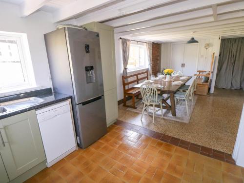 a kitchen and dining room with a table and refrigerator at Llanwern Farm in Fishguard